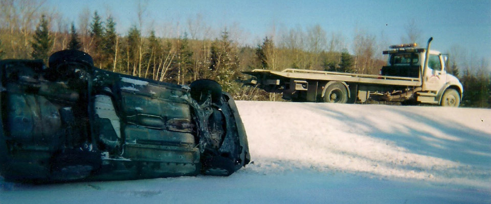 Truck pulling overturned car